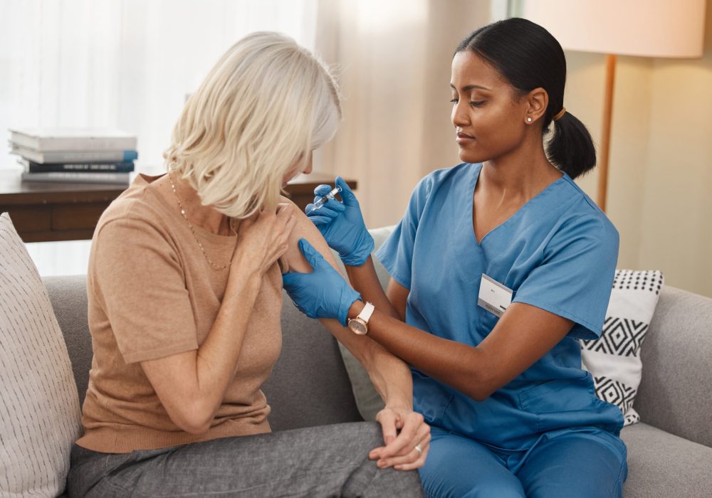 Shot of a doctor giving a senior woman an injection at home. Shot of a doctor giving a senior woman an injection at home.